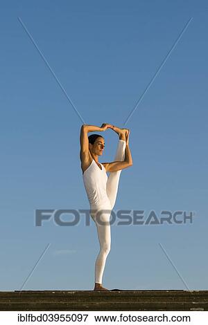 "Young woman practising Hatha yoga, outdoors, showing the pose Utthita Hasta Pandangusthasana, raised hand to big toe pose" View Large Photo Image Stock Photo - "Young woman practising Hatha yoga, outdoors, showing the pose Utthita Hasta Pandangusthasana, raised hand to big toe pose". Fotosearch