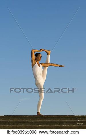 "Young woman practising Hatha yoga, outdoors, showing the pose Utthita Hasta Pandangusthasana, raised hand to big toe pose" View Large Photo Image Stock Photo - "Young woman practising Hatha yoga, outdoors, showing the pose Utthita Hasta Pandangusthasana, raised hand to big toe pose". Fotosearch