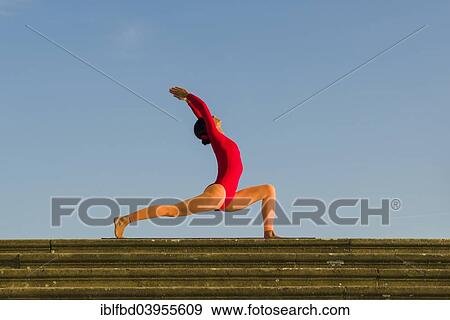 "Young woman practising Hatha yoga, outdoors, showing the pose Anjaneyasana, Chandrasana, half moon pose" View Large Photo Image Stock Photo - "Young woman practising Hatha yoga, outdoors, showing the pose Anjaneyasana, Chandrasana, half moon pose". Fotosearch