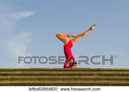 "Young woman practising Hatha yoga, outdoors, showing the pose Sirshasana, Head stand" View Large Photo Image Stock Photo - "Young woman practising Hatha yoga, outdoors, showing the pose Sirshasana, Head stand". Fotosearch