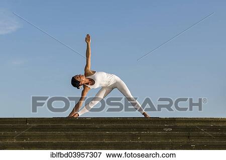 "Young woman practising Hatha yoga, outdoors, showing the pose Trikonasana, Triangle" View Large Photo Image Stock Photo - "Young woman practising Hatha yoga, outdoors, showing the pose Trikonasana, Triangle". Fotosearch