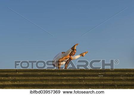"Young woman practising Hatha yoga, outdoors, showing the pose Kakasana, Bakasana, variation of Crow pose, Crane pose" View Large Photo Image Stock Photo - "Young woman practising Hatha yoga, outdoors, showing the pose Kakasana, Bakasana, variation of Crow pose, Crane pose". Fotosearch