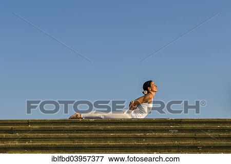 "Young woman practising Hatha yoga, outdoors, showing the pose Bhujangasana, Cobra pose" View Large Photo Image Stock Photo - "Young woman practising Hatha yoga, outdoors, showing the pose Bhujangasana, Cobra pose". Fotosearch