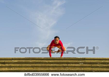 "Young woman practising Hatha yoga, outdoors, showing the pose Kakasana or Bakasana, Crow pose or Crane pose" View Large Photo Image Stock Photograph - "Young woman practising Hatha yoga, outdoors, showing the pose Kakasana or Bakasana, Crow pose or Crane pose". Fotosearch