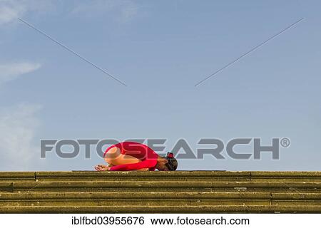 "Young woman practising Hatha yoga, outdoors, showing the pose Garbhasana, Child's pose" View Large Photo Image Stock Photograph - "Young woman practising Hatha yoga, outdoors, showing the pose Garbhasana, Child's pose". Fotosearch