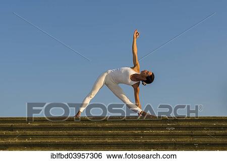 "Young woman practising Hatha yoga, outdoors, showing the pose Trikonasana, Triangle" View Large Photo Image Stock Photograph - "Young woman practising Hatha yoga, outdoors, showing the pose Trikonasana, Triangle". Fotosearch