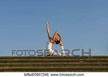 "Young woman practising Hatha yoga, outdoors, showing the pose Kapotasana, Pigeon pose" View Large Photo Image Stock Photograph - "Young woman practising Hatha yoga, outdoors, showing the pose Kapotasana, Pigeon pose". Fotosearch