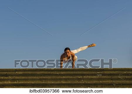 "Young woman practising Hatha yoga, outdoors, showing the pose Parshva kakasana, Parshva bakasana, Sideward crow pose, Sideward crane pose" View Large Photo Image Stock Photograph - "Young woman practising Hatha yoga, outdoors, showing the pose Parshva kakasana, Parshva bakasana, Sideward crow pose, Sideward crane pose". Fotosearch