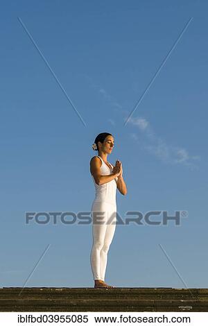 Stock Photography - "Young woman practising Hatha yoga, outdoors, showing the pose Tadasana, Pranamasana, Prayer pose". Fotosearch