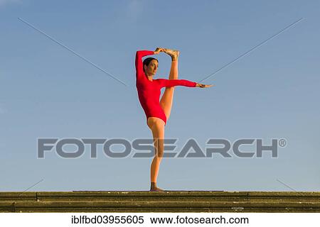 "Young woman practising Hatha yoga, outdoors, showing the pose Utthita Hasta Pandangusthasana, raised hand to big toe pose" View Large Photo Image Stock Photography - "Young woman practising Hatha yoga, outdoors, showing the pose Utthita Hasta Pandangusthasana, raised hand to big toe pose". Fotosearch