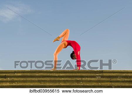 Stock Photography - "Young woman practising Hatha yoga, outdoors, showing the pose Chakrasana, Urdhva Dhanurasana, Wheel pose". Fotosearch
