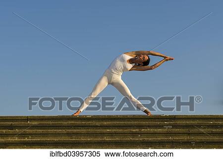 "Young woman practising Hatha yoga, outdoors, showing the pose Trikonasana, Triangle" View Large Photo Image Stock Photography - "Young woman practising Hatha yoga, outdoors, showing the pose Trikonasana, Triangle". Fotosearch