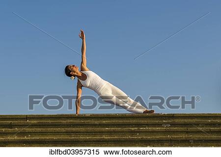 "Young woman practising Hatha yoga, outdoors, showing the pose Vasisthasana, Sage Vashishta's pose" View Large Photo Image Stock Photography - "Young woman practising Hatha yoga, outdoors, showing the pose Vasisthasana, Sage Vashishta's pose". Fotosearch