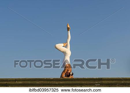 "Young woman practising Hatha yoga, outdoors, showing the pose Sirshasana, Head stand" View Large Photo Image Stock Photography - "Young woman practising Hatha yoga, outdoors, showing the pose Sirshasana, Head stand". Fotosearch