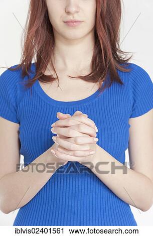 Stock Image - Young woman praying. Fotosearch