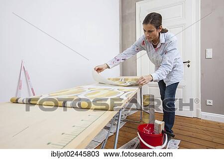 Young woman preparing wallpaper for wallpapering the walls View Large Photo Image Stock Image - Young woman preparing wallpaper for wallpapering the walls. Fotosearch