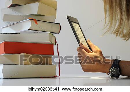 Young woman reading an e-book on a Kindle View Large Photo Image Stock Image - Young woman reading an e-book on a Kindle. Fotosearch