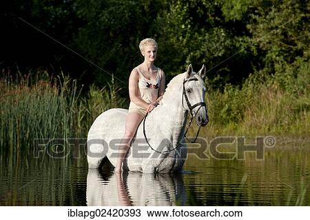 Young woman riding bareback on a Hanoverian horse through a lake View Large Photo Image Stock Image - Young woman riding bareback on a Hanoverian horse through a lake. Fotosearch