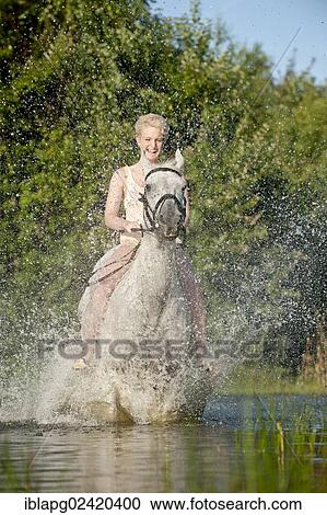 Young woman riding bareback on a Hanoverian horse through a lake View Large Photo Image Stock Image - Young woman riding bareback on a Hanoverian horse through a lake. Fotosearch