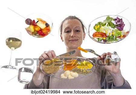 Young woman sitting at a glass table eating steak with vegetables and potatoes, salad and fruit salad for dessert View Large Photo Image Picture - Young woman sitting at a glass table eating steak with vegetables and potatoes, salad and fruit salad for dessert. Fotosearch