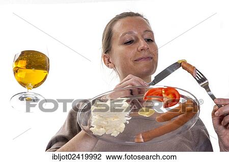 Young woman sitting at a glass table eating Frankfurter sausages with potato salad, mustard and a pilsner beer View Large Photo Image Stock Image - Young woman sitting at a glass table eating Frankfurter sausages with potato salad, mustard and a pilsner beer. Fotosearch