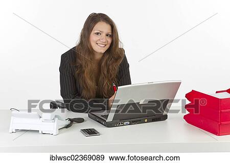 Young woman sitting at a laptop View Large Photo Image Stock Photo - Young woman sitting at a laptop. Fotosearch
