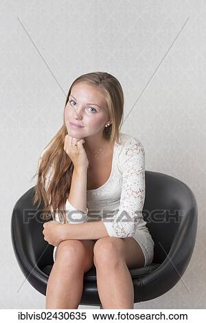 Young woman sitting in a vintage chair View Large Photo Image Stock Photography - Young woman sitting in a vintage chair. Fotosearch