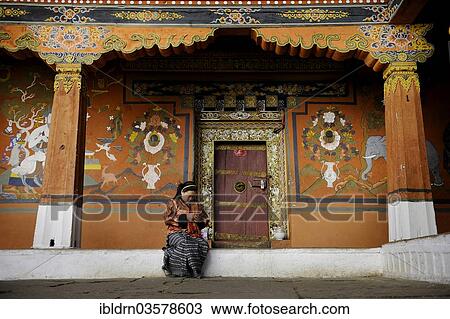 "Young woman sitting in front of the ornate entrance of a side temple at the Paro Dzong, Rinpung Dzong fortress, Paro, Paro district, Bhutan, Asia" View Large Photo Image Stock Image - "Young woman sitting in front of the ornate entrance of a side temple at the Paro Dzong, Rinpung Dzong fortress, Paro, Paro district, Bhutan, Asia". Fotosearch