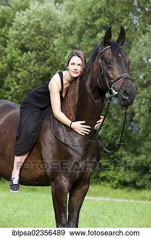 "Young woman sitting on a horse and cuddling its neck, Hanoverian horse, bay, North Tyrol, Austria, Europe" View Large Photo Image Stock Photo - "Young woman sitting on a horse and cuddling its neck, Hanoverian horse, bay, North Tyrol, Austria, Europe". Fotosearch