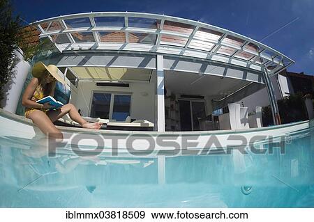 "Young woman sitting on the edge of a private pool, Germany, Europe" View Large Photo Image Stock Photo - "Young woman sitting on the edge of a private pool, Germany, Europe". Fotosearch