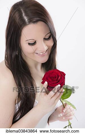 Young woman smiling at a red rose View Large Photo Image Picture - Young woman smiling at a red rose. Fotosearch