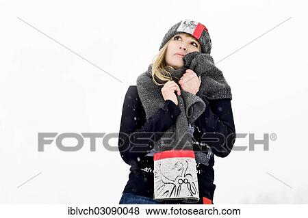Stock Photo - "Young woman snuggling up in her shawl, Austria, Europe". Fotosearch