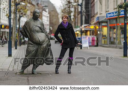 "Young woman standing beside a bronze figure in the pedestrian zone, Grevenbroich, North Rhine-Westphalia, Germany, Europe" View Large Photo Image Picture - "Young woman standing beside a bronze figure in the pedestrian zone, Grevenbroich, North Rhine-Westphalia, Germany, Europe". Fotosearch