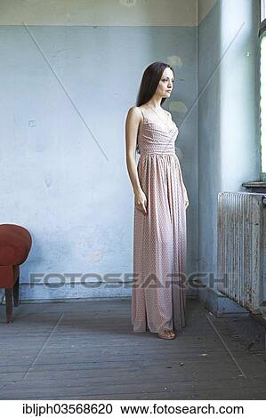 Stock Image - "Young woman standing in a room in need of redecoration, Germany, Europe". Fotosearch