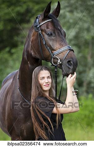 "Young woman standing with a Hanoverian horse, bay, North Tyrol, Austria, Europe" View Large Photo Image Picture - "Young woman standing with a Hanoverian horse, bay, North Tyrol, Austria, Europe". Fotosearch