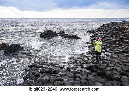 "Young woman taking pictures of the basalt rocks, Giant Causeway, Coleraine, Northern Ireland, United Kingdom, Europe" View Large Photo Image Stock Photograph - "Young woman taking pictures of the basalt rocks, Giant Causeway, Coleraine, Northern Ireland, United Kingdom, Europe". Fotosearch