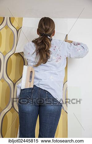 Young woman wallpapering a wall View Large Photo Image Stock Photography - Young woman wallpapering a wall. Fotosearch