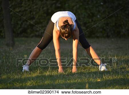 Picture - "Young woman warming up, stretching exercises, Stuttgart, Baden-Wuerttemberg, Germany, Europe, PublicGround, Europe". Fotosearch