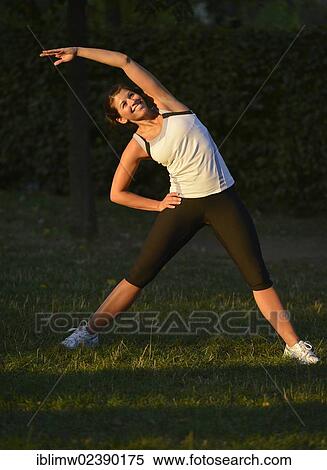 Stock Photography - "Young woman warming up, stretching exercises, Stuttgart, Baden-Wuerttemberg, Germany, Europe, PublicGround, Europe". Fotosearch