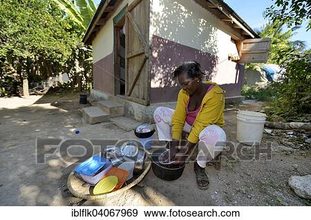 "Young woman washing the laundry in front of the house which was given to the family by a relief organisation, Ridore, La Vallee, Sud-Est Department, Haiti, North America" View Large Photo Image Stock Photo - "Young woman washing the laundry in front of the house which was given to the family by a relief organisation, Ridore, La Vallee, Sud-Est Department, Haiti, North America". Fotosearch