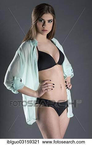 Young woman wearing a black bikini View Large Photo Image Stock Image - Young woman wearing a black bikini. Fotosearch