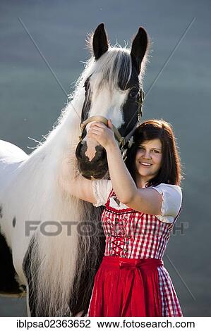 "Young woman wearing a dirndl cuddling with a Gypsy Vanner or Tinker horse, pinto, black and white, North Tyrol, Austria, Europe" View Large Photo Image Stock Image - "Young woman wearing a dirndl cuddling with a Gypsy Vanner or Tinker horse, pinto, black and white, North Tyrol, Austria, Europe". Fotosearch