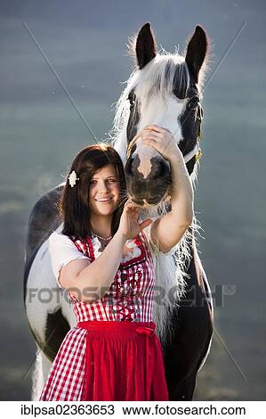 "Young woman wearing a dirndl cuddling with a Gypsy Vanner or Tinker horse, pinto, black and white, North Tyrol, Austria, Europe" View Large Photo Image Stock Image - "Young woman wearing a dirndl cuddling with a Gypsy Vanner or Tinker horse, pinto, black and white, North Tyrol, Austria, Europe". Fotosearch