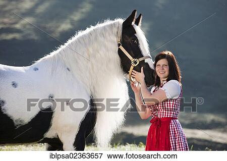"Young woman wearing a dirndl cuddling with a Gypsy Vanner or Tinker horse, pinto, black and white, North Tyrol, Austria, Europe" View Large Photo Image Stock Photo - "Young woman wearing a dirndl cuddling with a Gypsy Vanner or Tinker horse, pinto, black and white, North Tyrol, Austria, Europe". Fotosearch