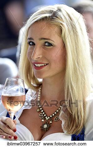 "Young woman wearing a dirndl dress holding a wine glass, Stuttgart, Baden-Wurttemberg, Germany, Europe" View Large Photo Image Stock Photo - "Young woman wearing a dirndl dress holding a wine glass, Stuttgart, Baden-Wurttemberg, Germany, Europe". Fotosearch