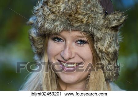 "Young woman wearing a fur hat, smiling, portrait" View Large Photo Image Stock Image - "Young woman wearing a fur hat, smiling, portrait". Fotosearch