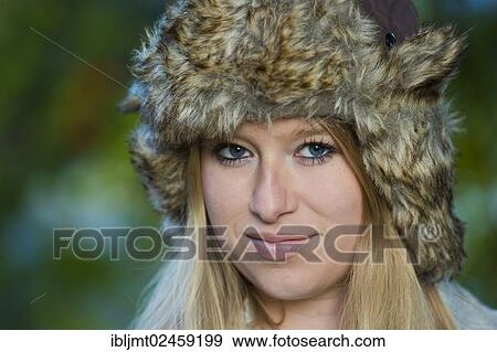 Stock Photo - "Young woman wearing a fur hat, portrait". Fotosearch