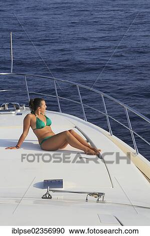 "Young woman wearing a green bikini sitting on the front sun deck of a motor yacht, French Riviera, Cote d'Azur, Mediterranean Sea, Europe" View Large Photo Image Stock Image - "Young woman wearing a green bikini sitting on the front sun deck of a motor yacht, French Riviera, Cote d'Azur, Mediterranean Sea, Europe". Fotosearch