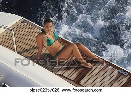 "Young woman wearing a green bikini sitting on a teak covered swim platform of a moving motor yacht, French Riviera, Cote d'Azur, France, Mediterranean, Europe" View Large Photo Image Stock Photograph - "Young woman wearing a green bikini sitting on a teak covered swim platform of a moving motor yacht, French Riviera, Cote d'Azur, France, Mediterranean, Europe". Fotosearch