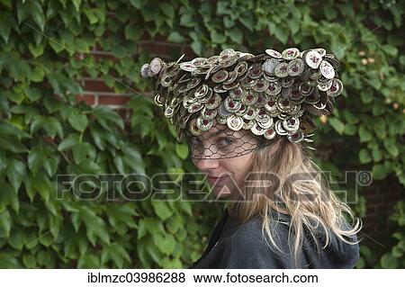 "Young woman wearing a hat made of crown corks in front of a wall of leaves, Germany, Europe" View Large Photo Image Stock Photo - "Young woman wearing a hat made of crown corks in front of a wall of leaves, Germany, Europe". Fotosearch